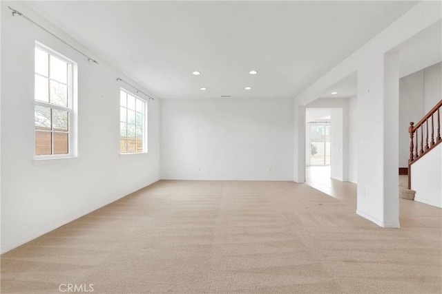 empty room featuring recessed lighting, stairway, and light carpet