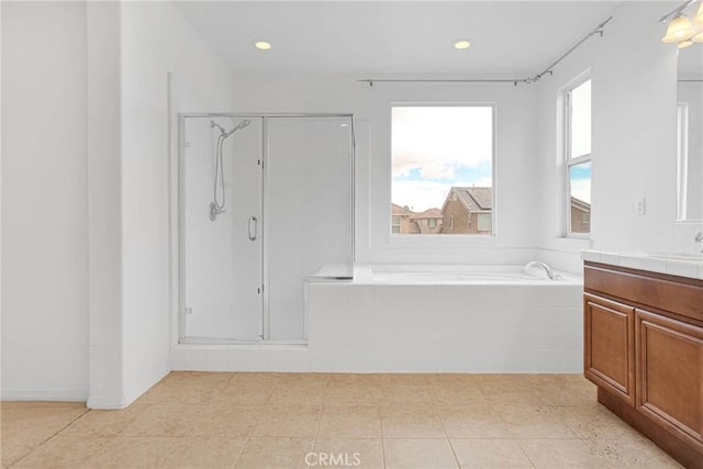 bathroom with recessed lighting, vanity, a bath, and a shower stall