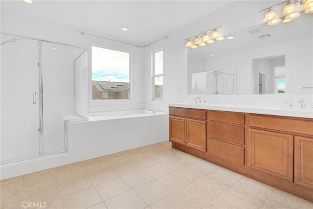 bathroom with visible vents, a garden tub, a sink, a shower stall, and double vanity