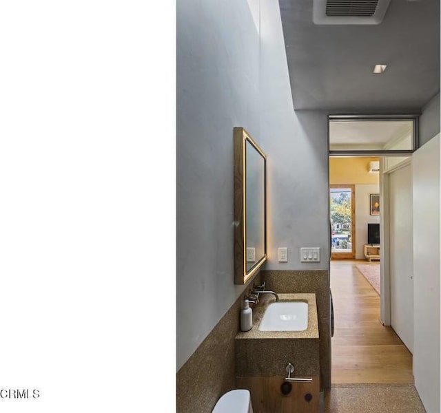 bathroom with a sink, visible vents, and wood finished floors