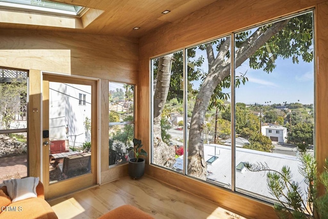 unfurnished sunroom with wooden ceiling and a skylight