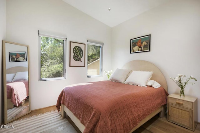 bedroom featuring wood finished floors and vaulted ceiling