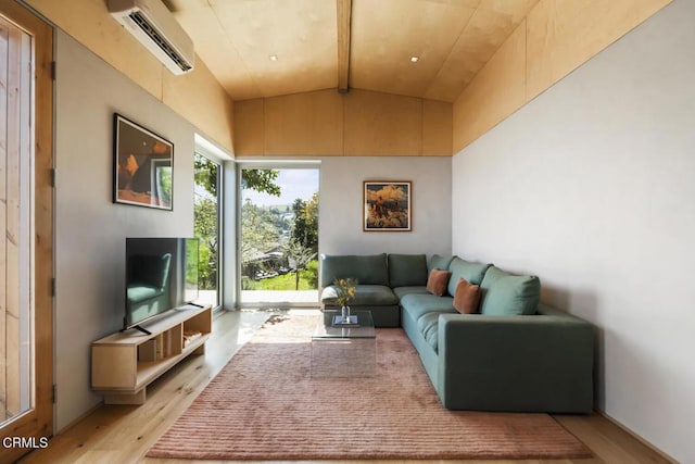 living room with a wall mounted air conditioner, light wood-style floors, and vaulted ceiling