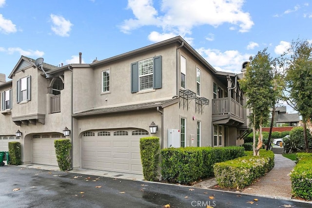 townhome / multi-family property with an attached garage, driveway, and stucco siding