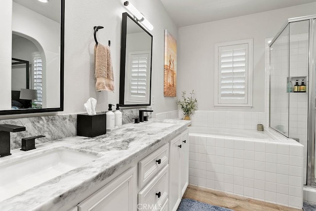 full bath featuring double vanity, a stall shower, and a sink