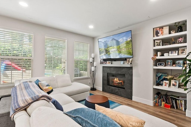 living room with recessed lighting, baseboards, wood finished floors, and a tiled fireplace