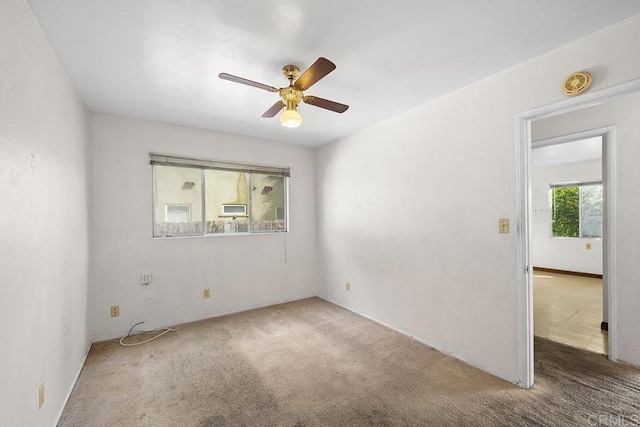 carpeted spare room with a ceiling fan