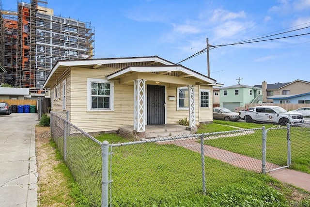 bungalow with a fenced front yard, a front lawn, and a gate