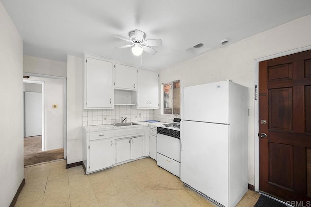 kitchen featuring tile countertops, white cabinets, white appliances, a ceiling fan, and a sink