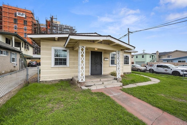 bungalow-style house with a front lawn and fence