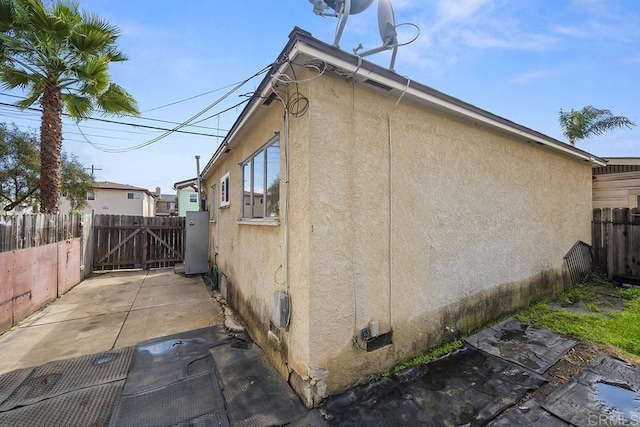 view of home's exterior with a patio area, fence, and stucco siding