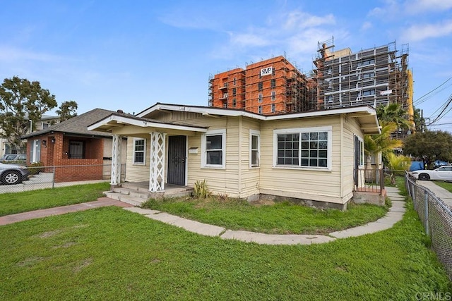 view of front of house featuring a front lawn and fence