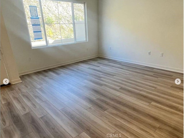 empty room featuring baseboards and wood finished floors