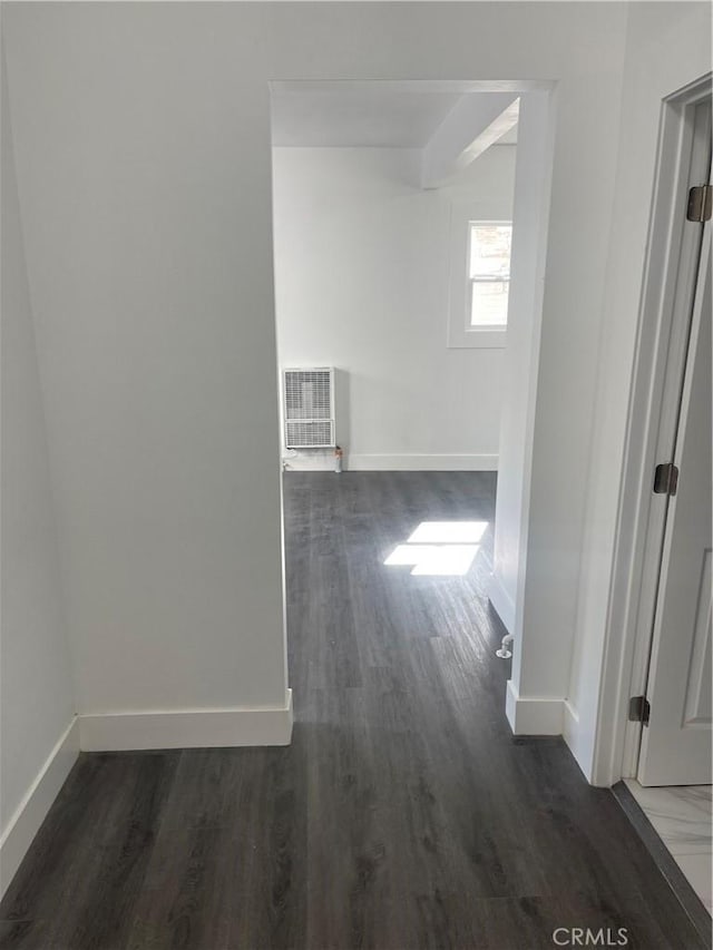 hallway with visible vents, baseboards, and wood finished floors