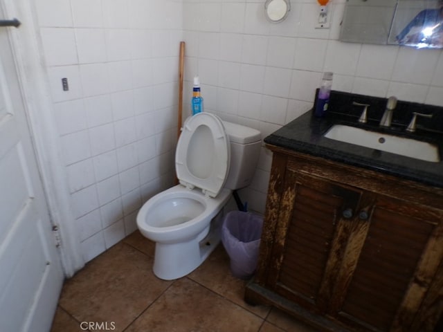 bathroom featuring tile patterned floors, toilet, tile walls, decorative backsplash, and vanity