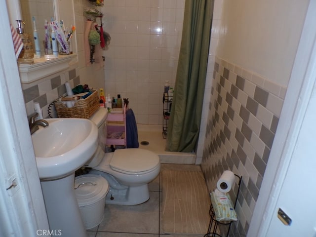 bathroom featuring a shower stall, tile walls, toilet, and tile patterned floors