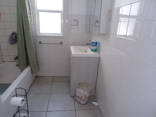 bathroom with tile patterned flooring, shower / bath combo with shower curtain, tile walls, and vanity