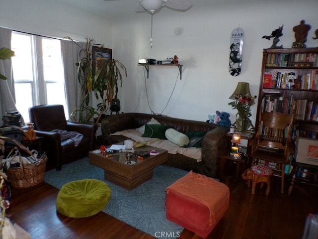 living area with wood finished floors and a ceiling fan