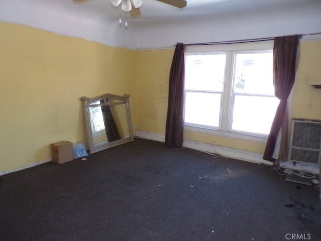 spare room with ceiling fan, carpet flooring, and a wall unit AC