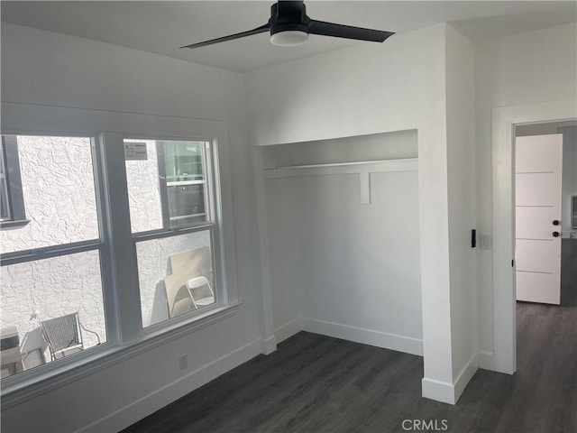 unfurnished bedroom with dark wood-type flooring, a ceiling fan, and baseboards