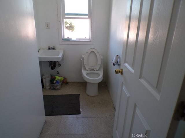 bathroom featuring a sink, toilet, and tile patterned floors