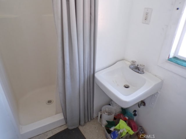 bathroom with a sink and a shower stall