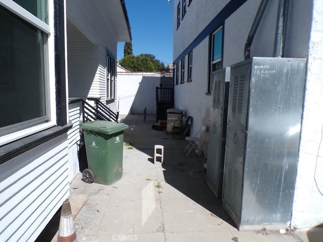 view of side of property with fence and stucco siding