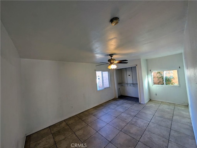 unfurnished bedroom with a closet, light tile patterned floors, and ceiling fan