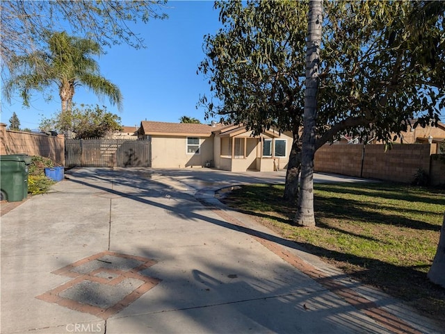 view of front of house featuring a front yard, fence, and stucco siding