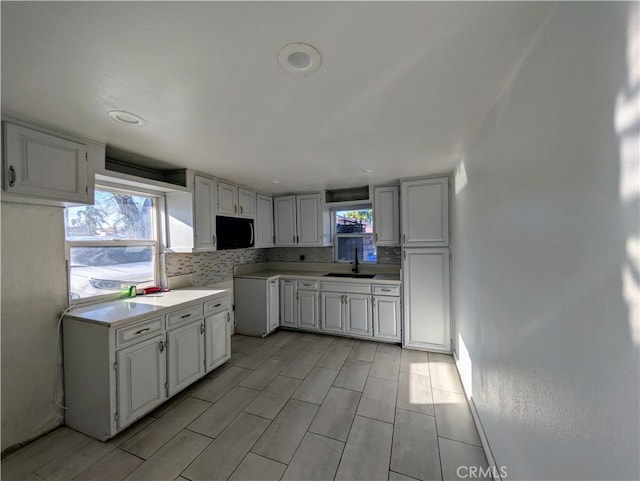 kitchen featuring a healthy amount of sunlight, backsplash, and a sink