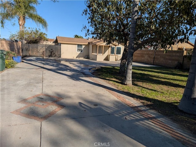 single story home featuring fence, driveway, and stucco siding