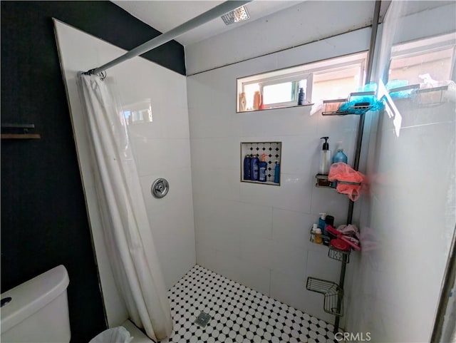 bathroom featuring a stall shower and toilet