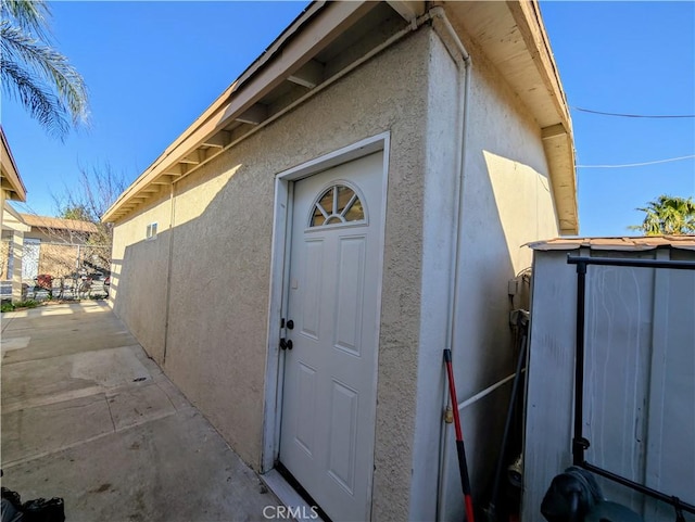 entrance to property featuring stucco siding