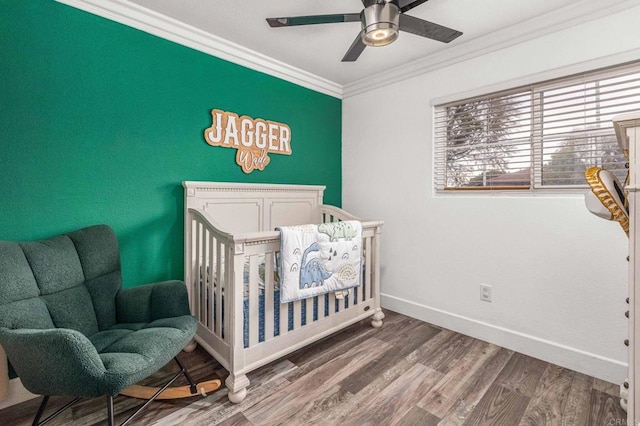 bedroom with baseboards, multiple windows, wood finished floors, and crown molding