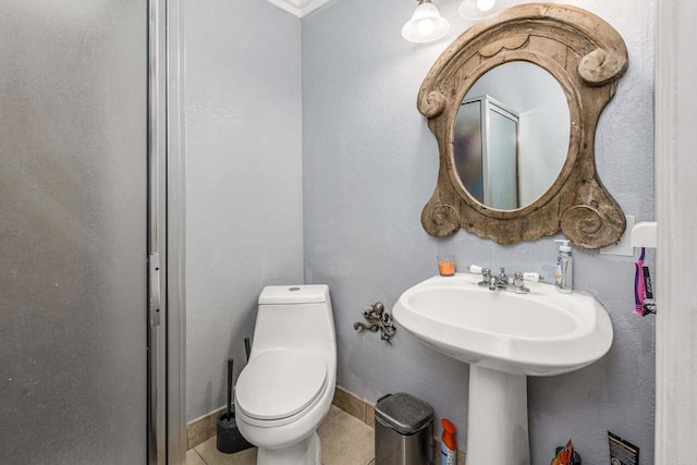 bathroom featuring tile patterned floors, toilet, and baseboards