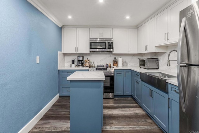 kitchen featuring blue cabinets, stainless steel appliances, backsplash, and dark wood-style floors