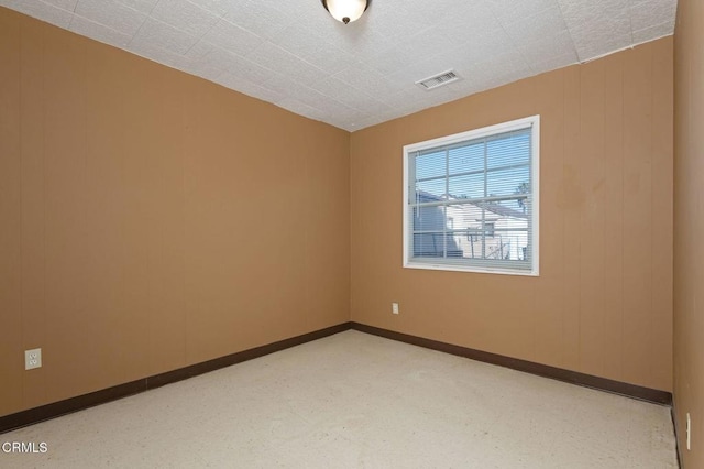 empty room featuring baseboards and visible vents