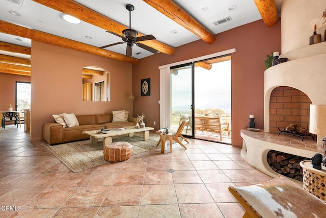 living room with light tile patterned floors, visible vents, beamed ceiling, and a ceiling fan