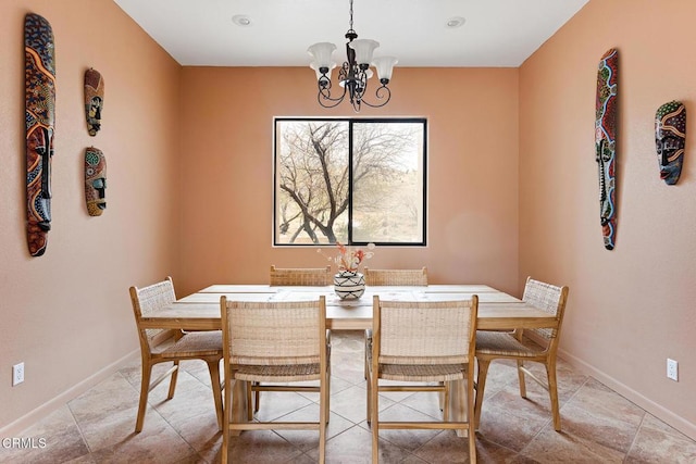 dining room featuring baseboards and a chandelier