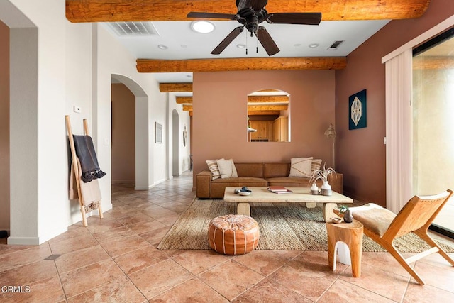 living room featuring arched walkways, visible vents, a ceiling fan, and beam ceiling