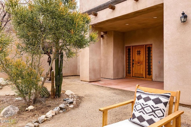 property entrance with a patio area and stucco siding