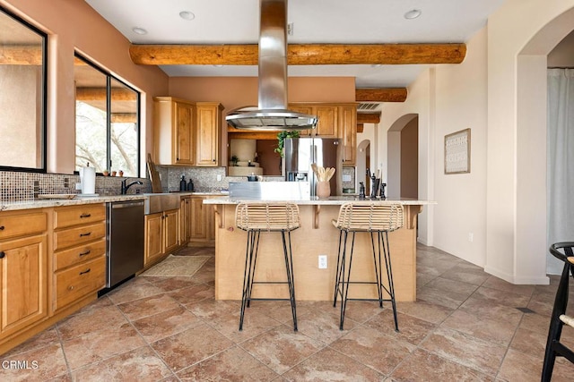 kitchen with tasteful backsplash, light countertops, stainless steel refrigerator with ice dispenser, island range hood, and arched walkways