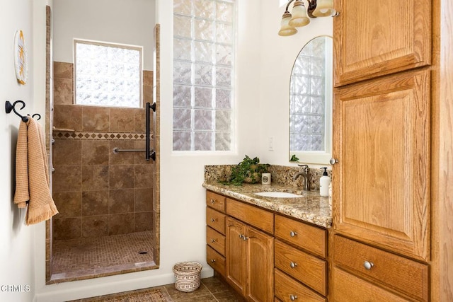 full bathroom with tile patterned flooring, vanity, and a walk in shower