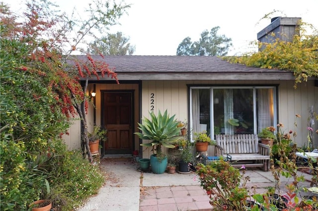 entrance to property with roof with shingles