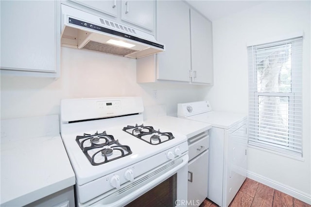 kitchen with washer / clothes dryer, white gas stove, light countertops, and under cabinet range hood