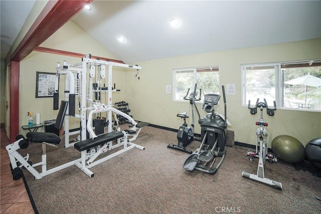 workout area featuring tile patterned flooring, vaulted ceiling, and baseboards