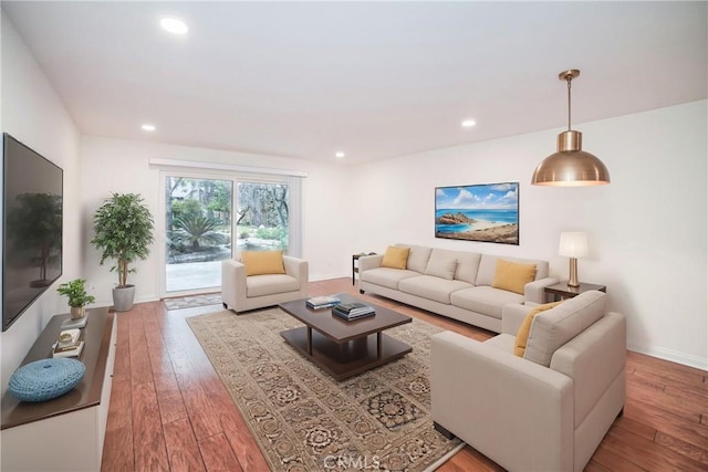 living room with recessed lighting, baseboards, and wood-type flooring
