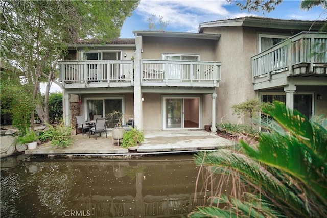 back of house featuring stucco siding and a patio area
