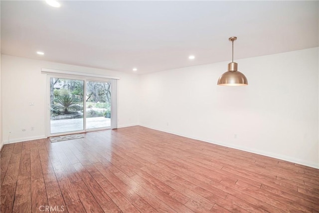 empty room with recessed lighting, baseboards, and light wood-style floors