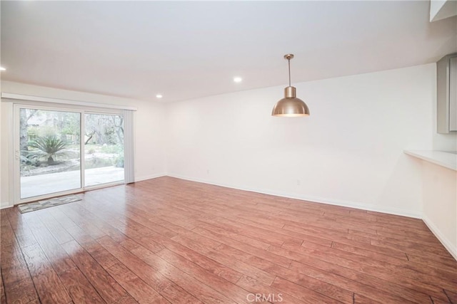 unfurnished room featuring recessed lighting, baseboards, and wood-type flooring